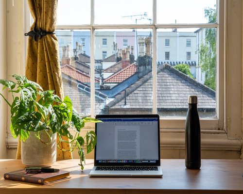 organized work desk with water and natural light